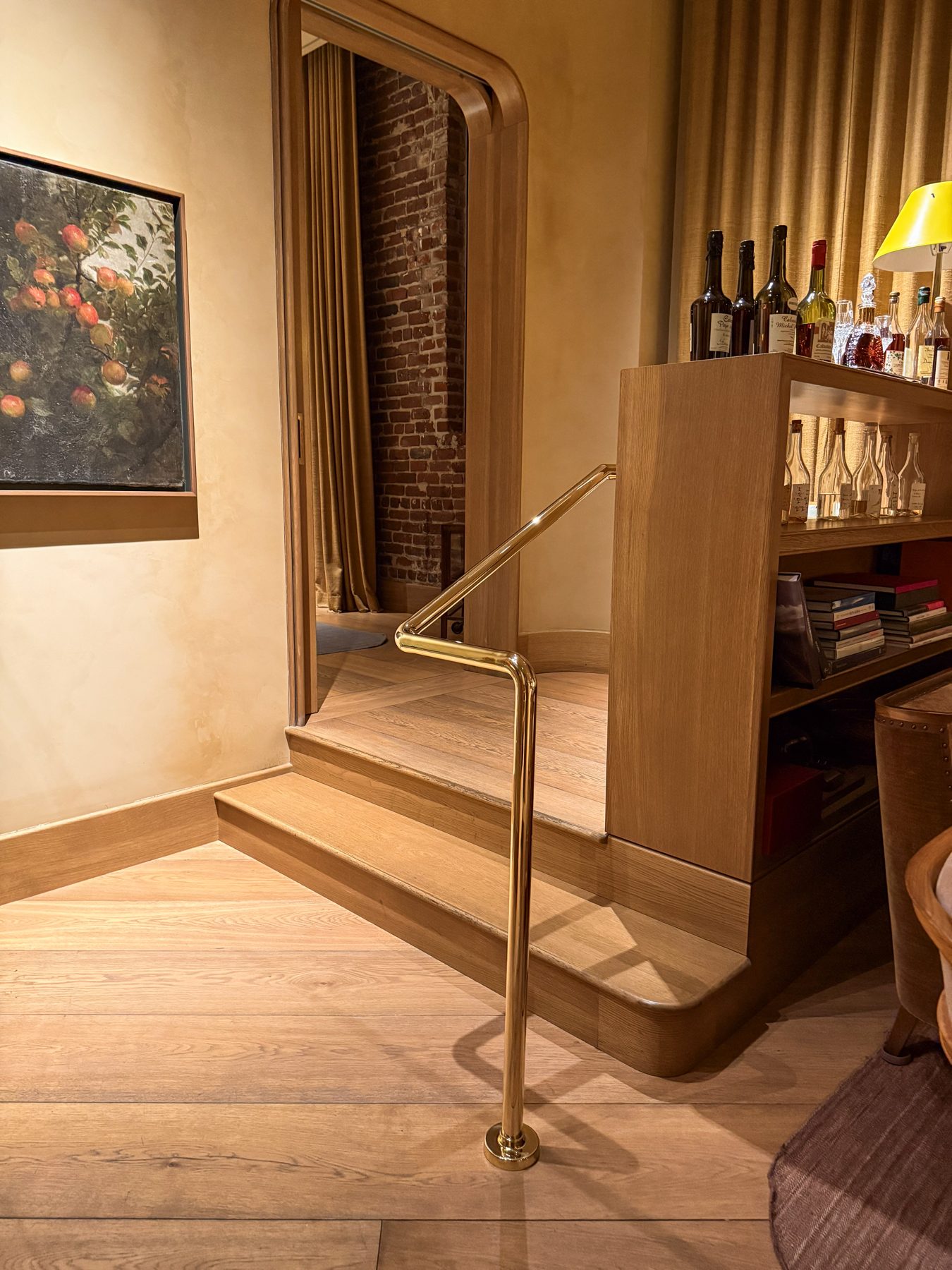 Polished brass handrail on a wood stair